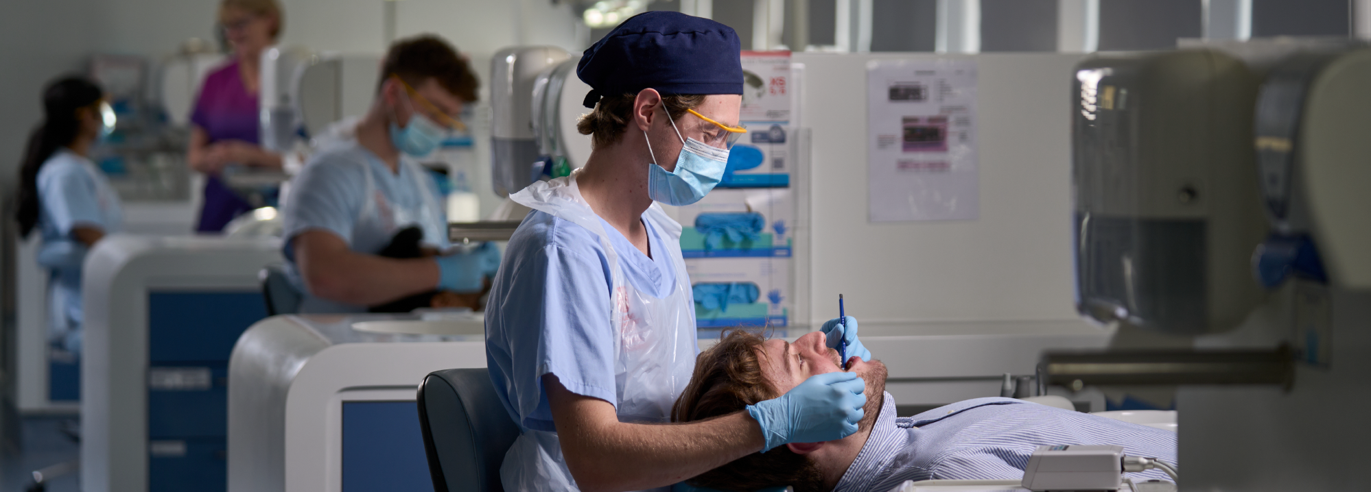 A dentistry student works on a patient